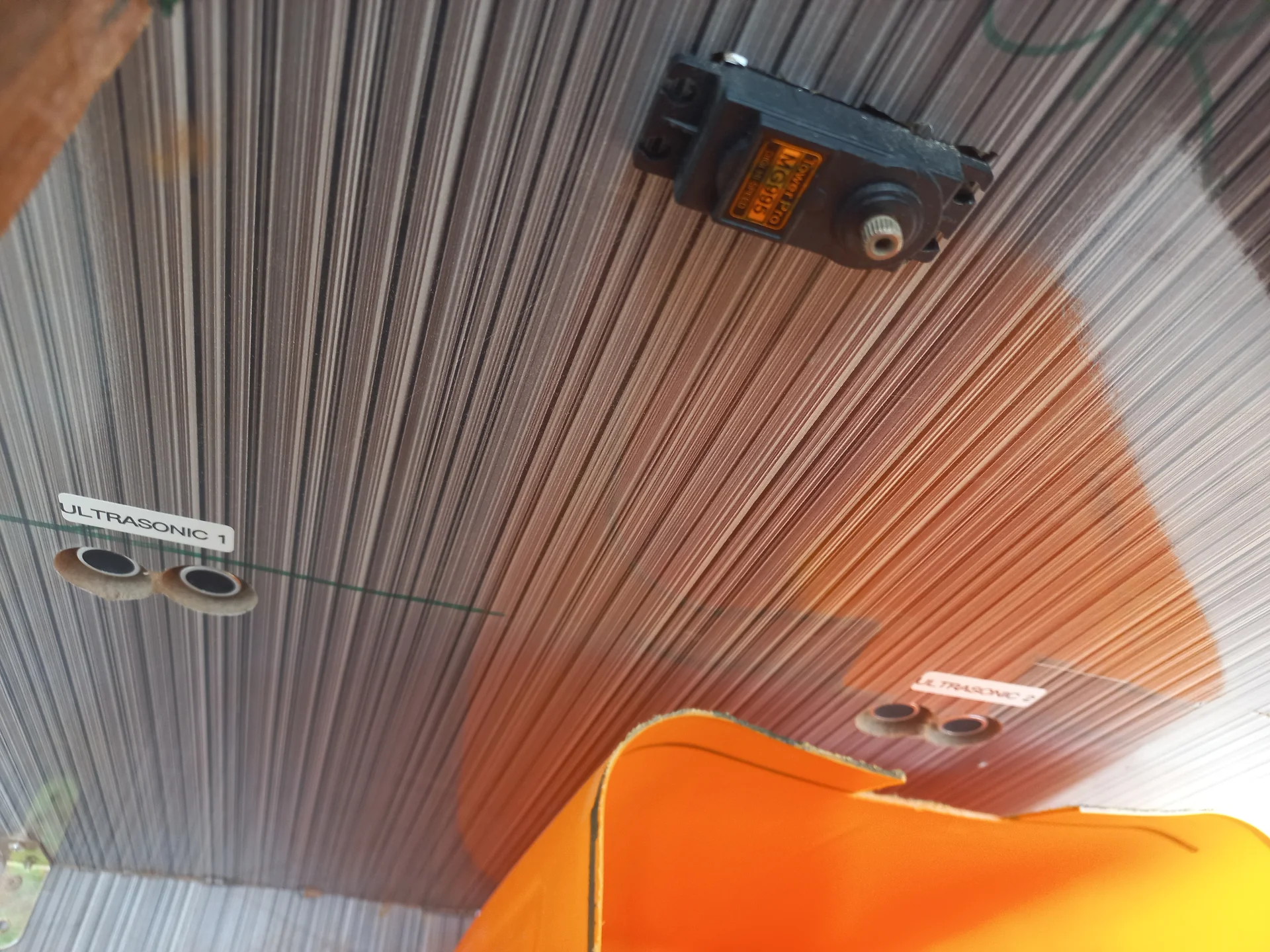 Inside the bin looking down, with the servo motor mounted at the top and two ultrasonic sensors visible on the walls