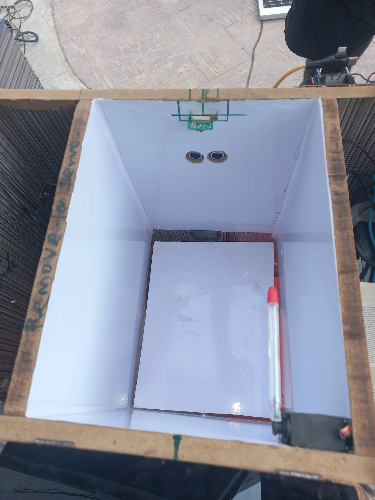 Top-down view of the sorting chamber with sensors on the walls and the camera lens visible at the top