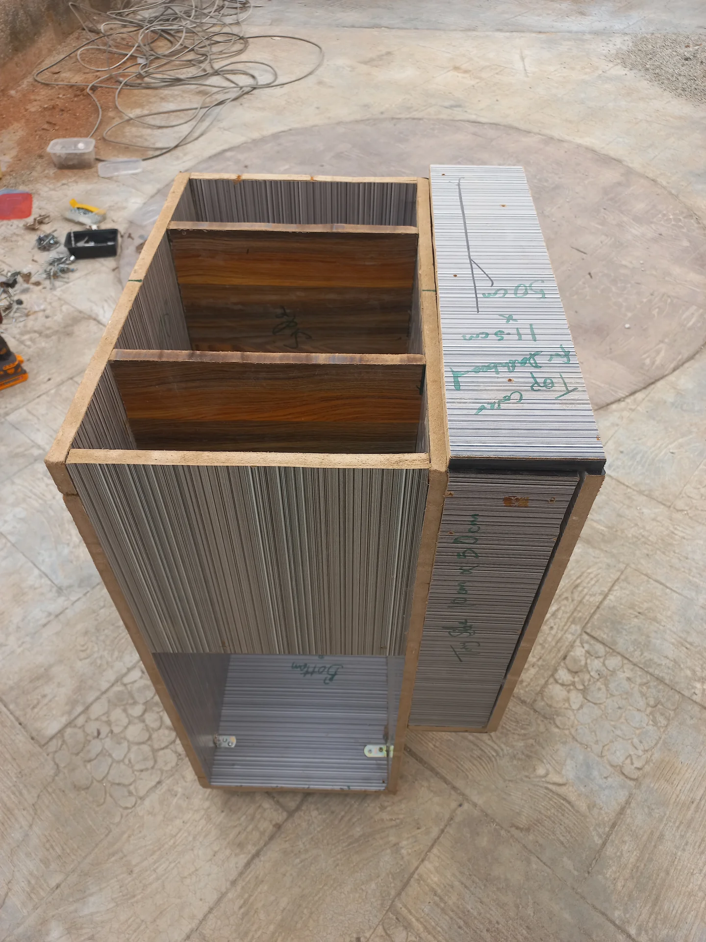 Angled exterior view of the bin showing the two upper compartments open at the top, the rectangular front opening, and the lower bay