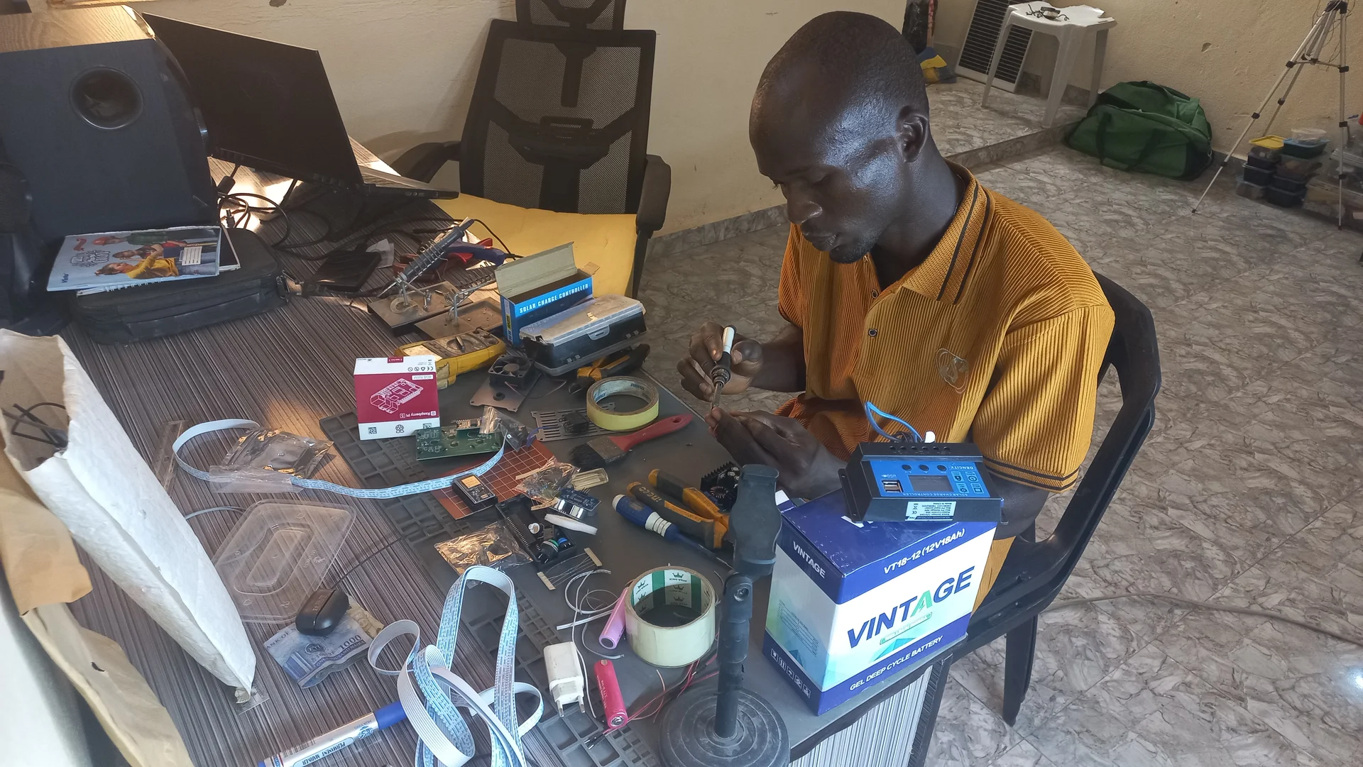 Builder at the work desk with components spread across the surface, in the middle of an early wiring session