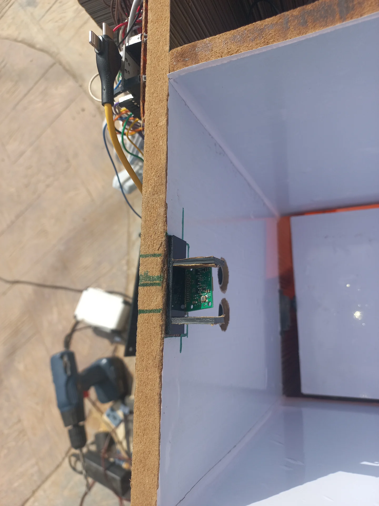 View of the Pi Camera module mounted in its bracket at the top of the bin wall, angled downward to look into the sorting chamber