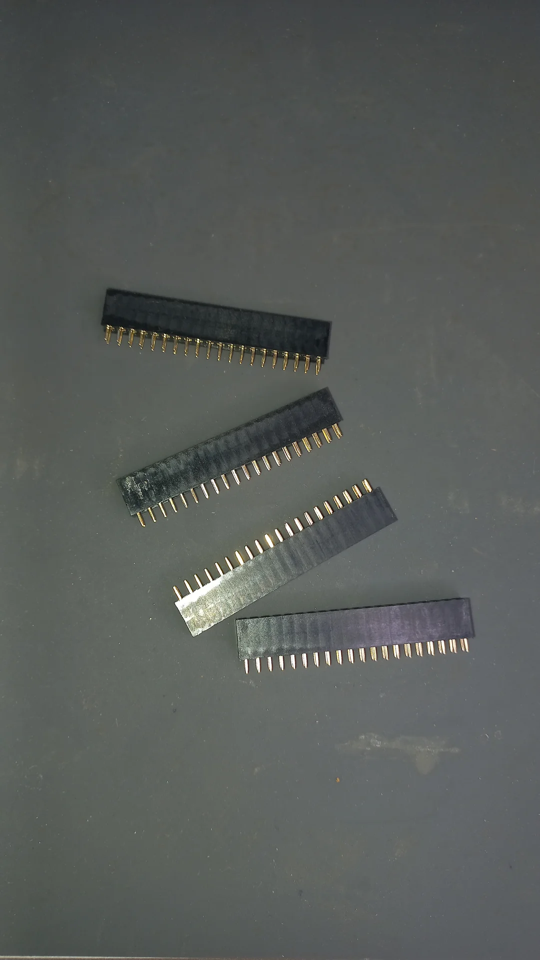 Four female GPIO pin-header socket strips laid out, used for socketed connections on the circuit board