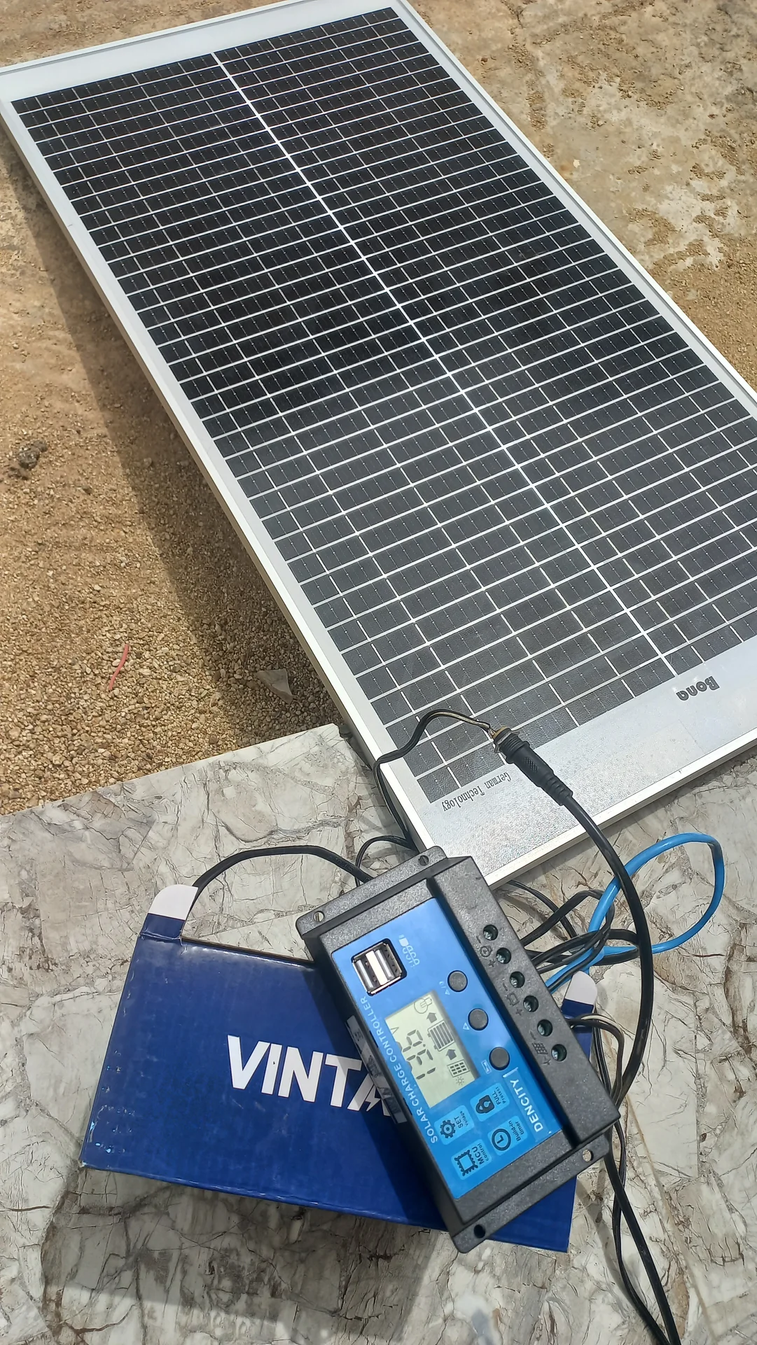 Solar panel, 12 V battery and the charge controller connected together outdoors for a first power test