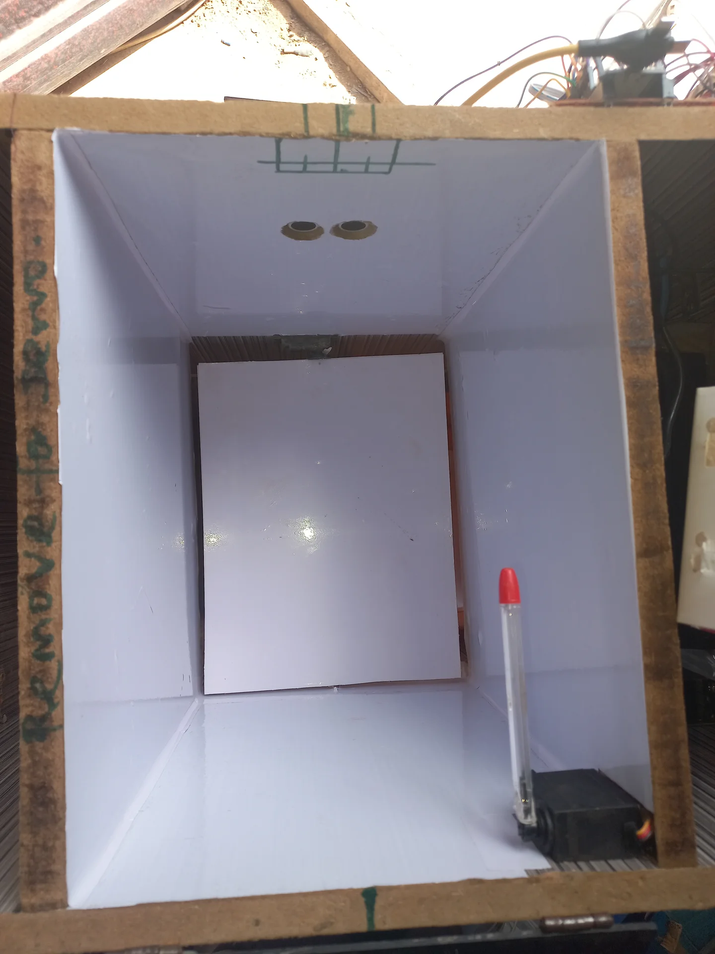 Front-on view into the bin interior showing the ultrasonic sensors on the back wall, the white sorting tray panel, and the servo motor at the bottom right