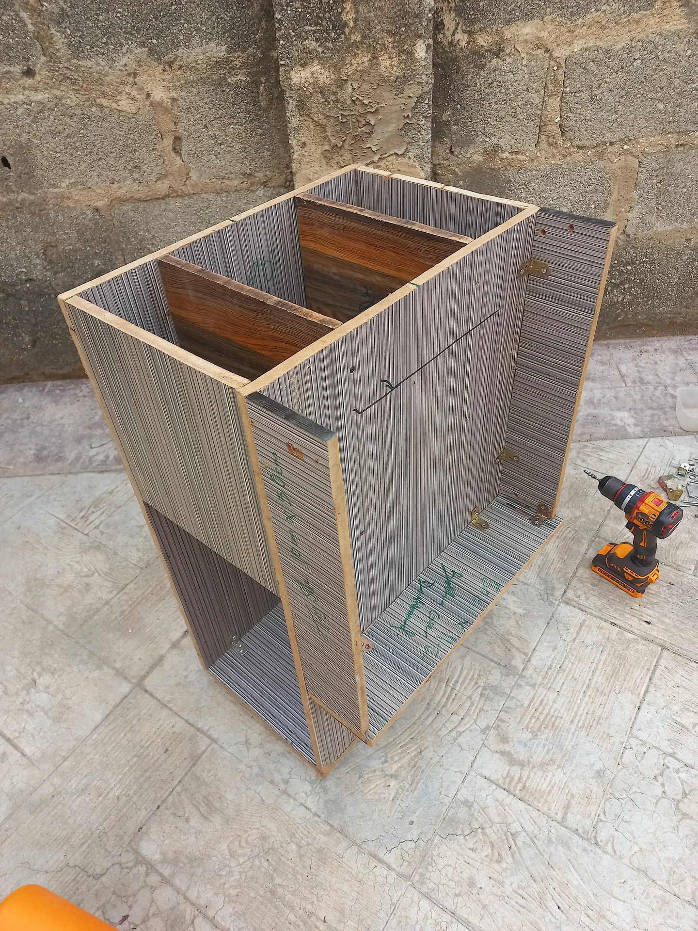 Elevated front view of the bin under construction without its top panel, showing the two upper sorting compartments and the lower open bay