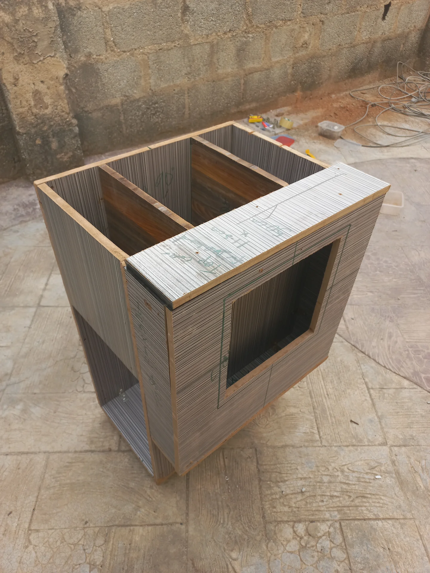 Elevated view of the bin with a rectangular opening cut into the front upper panel, marked with green measurement annotations, and the two sorting compartments visible at the top