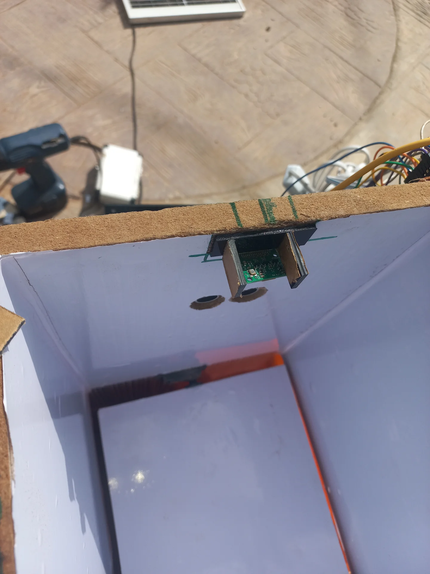 Top-down interior view of the Pi Camera bracket mounted at the top rim of the bin, showing the camera PCB angled into the sorting chamber