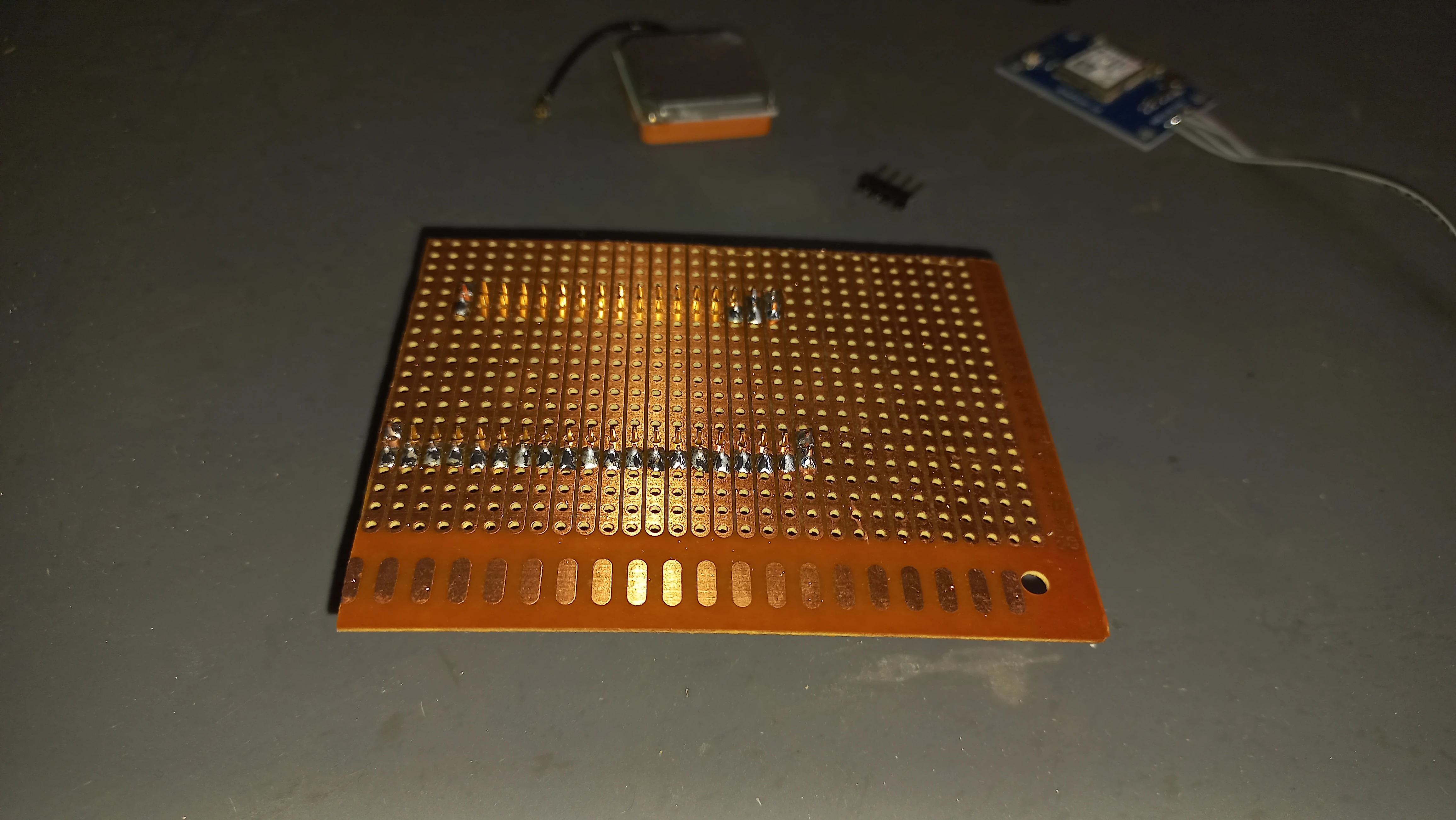 Perfboard with headers being soldered