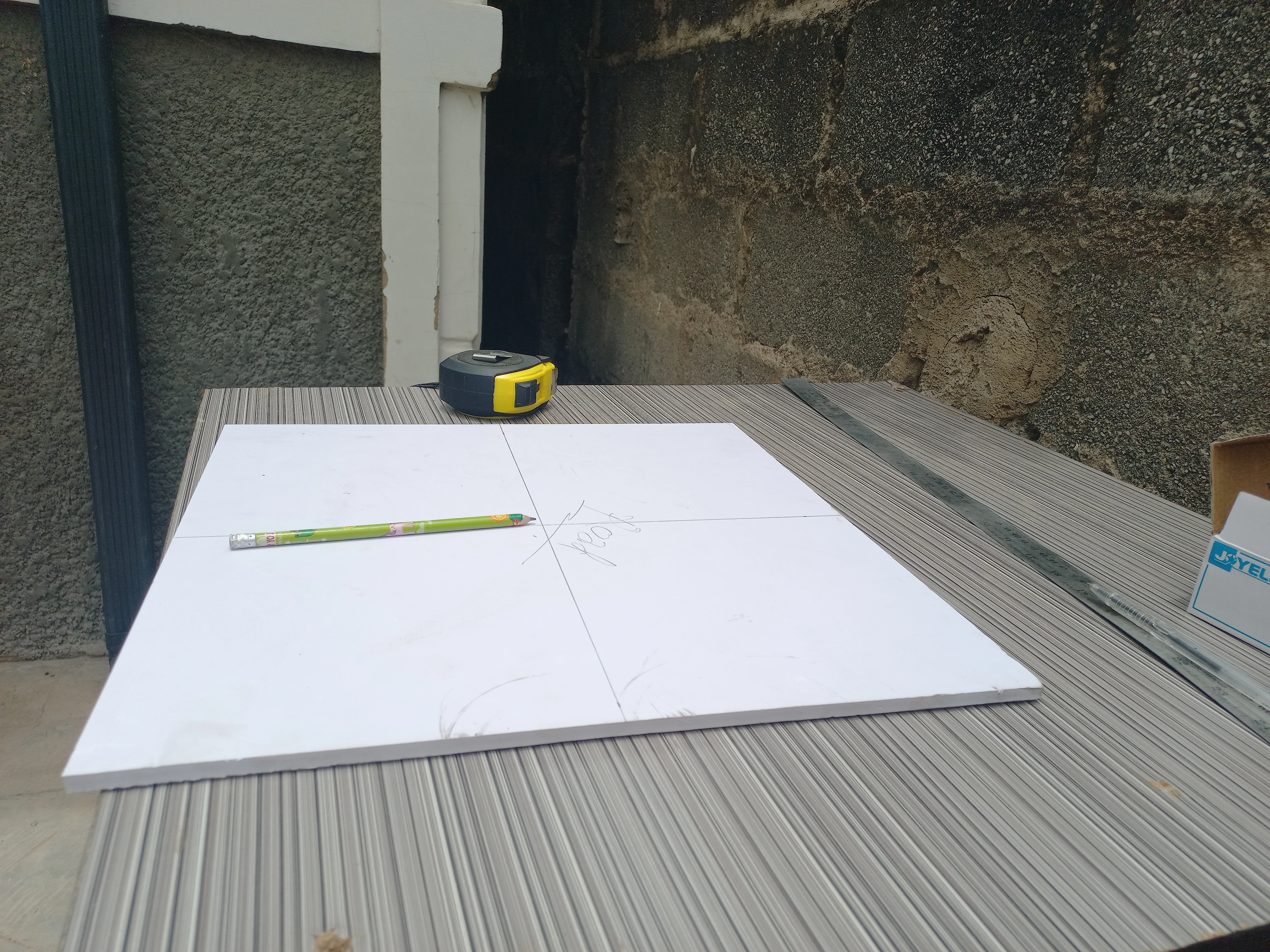 Base board flat on the workbench with the four-arm crossroads layout being planned out