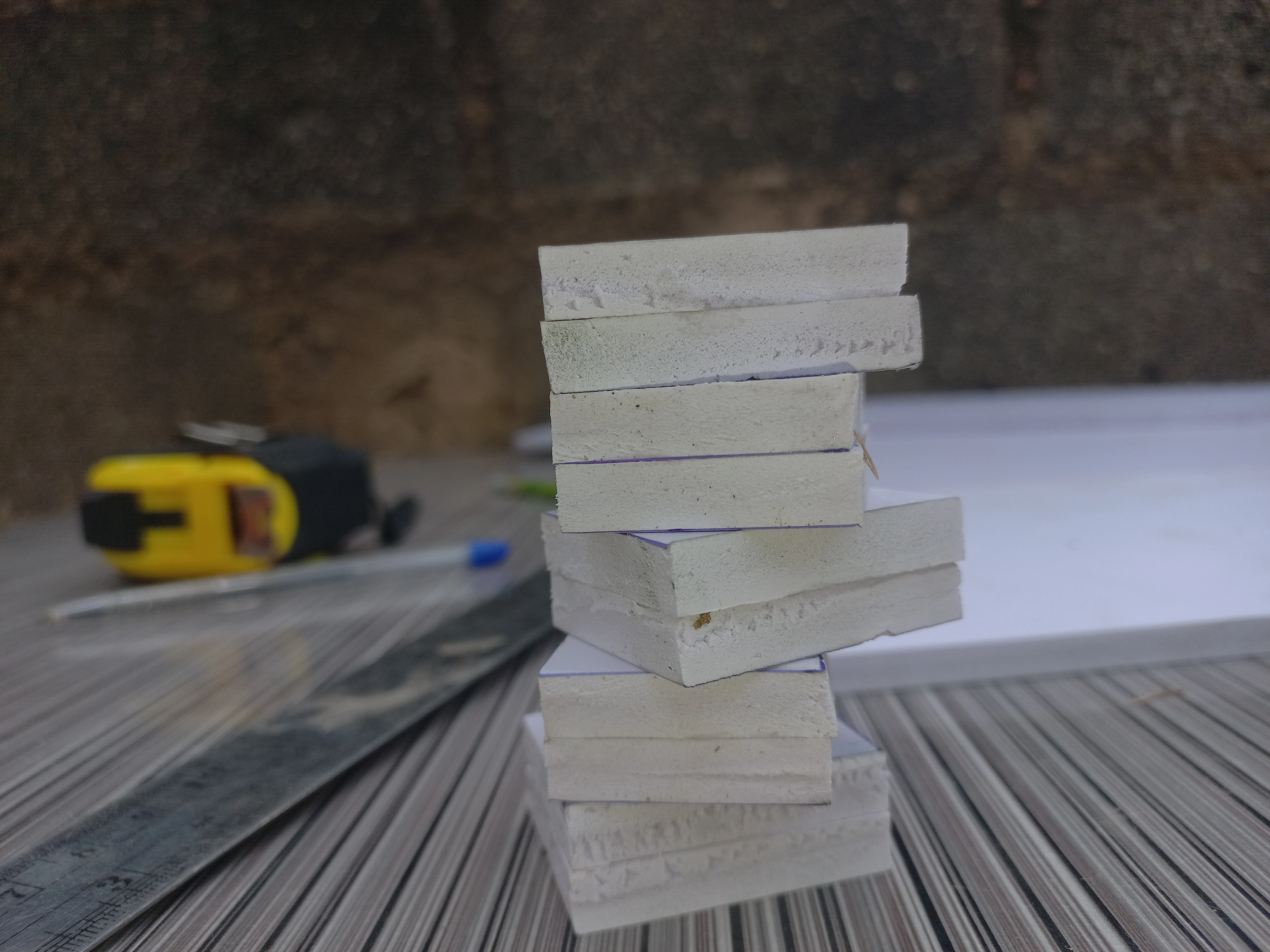 Cut foam tile squares stacked in a pile, ready for assembly onto the base board