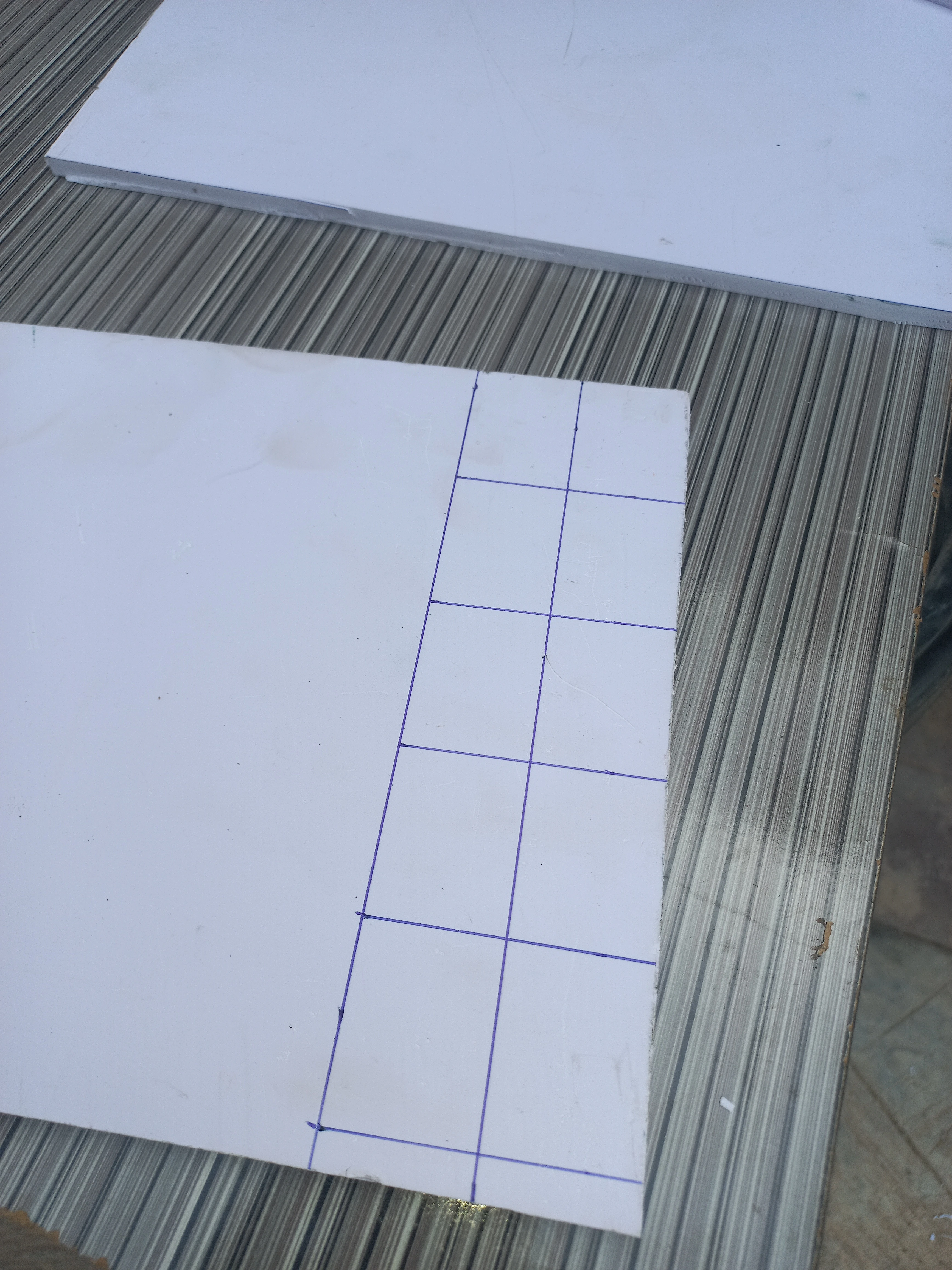 Grid and road layout geometry penciled directly onto the PVC board before cutting