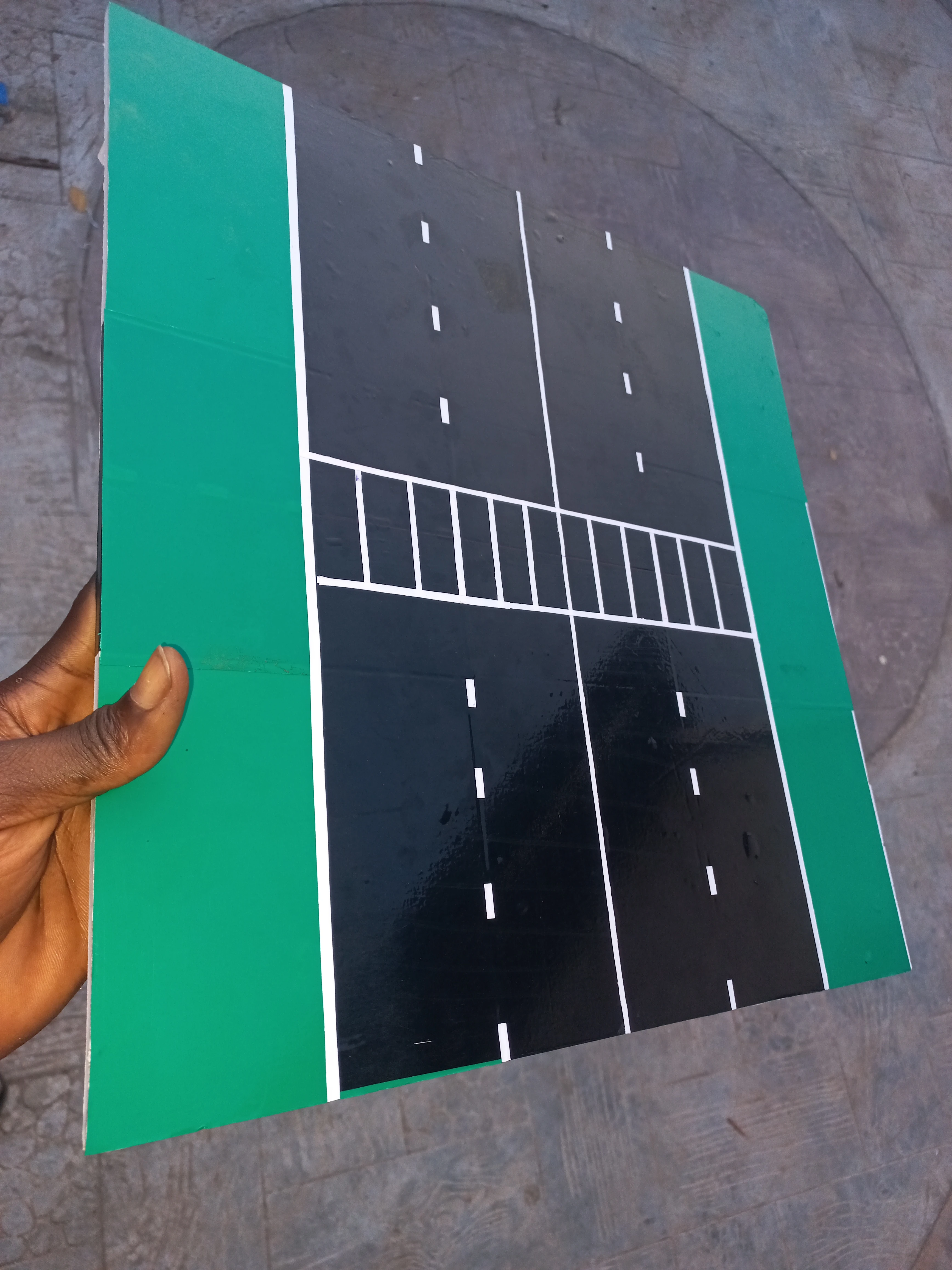 Developer holding the completed road model to show the pedestrian crossing and full road layout