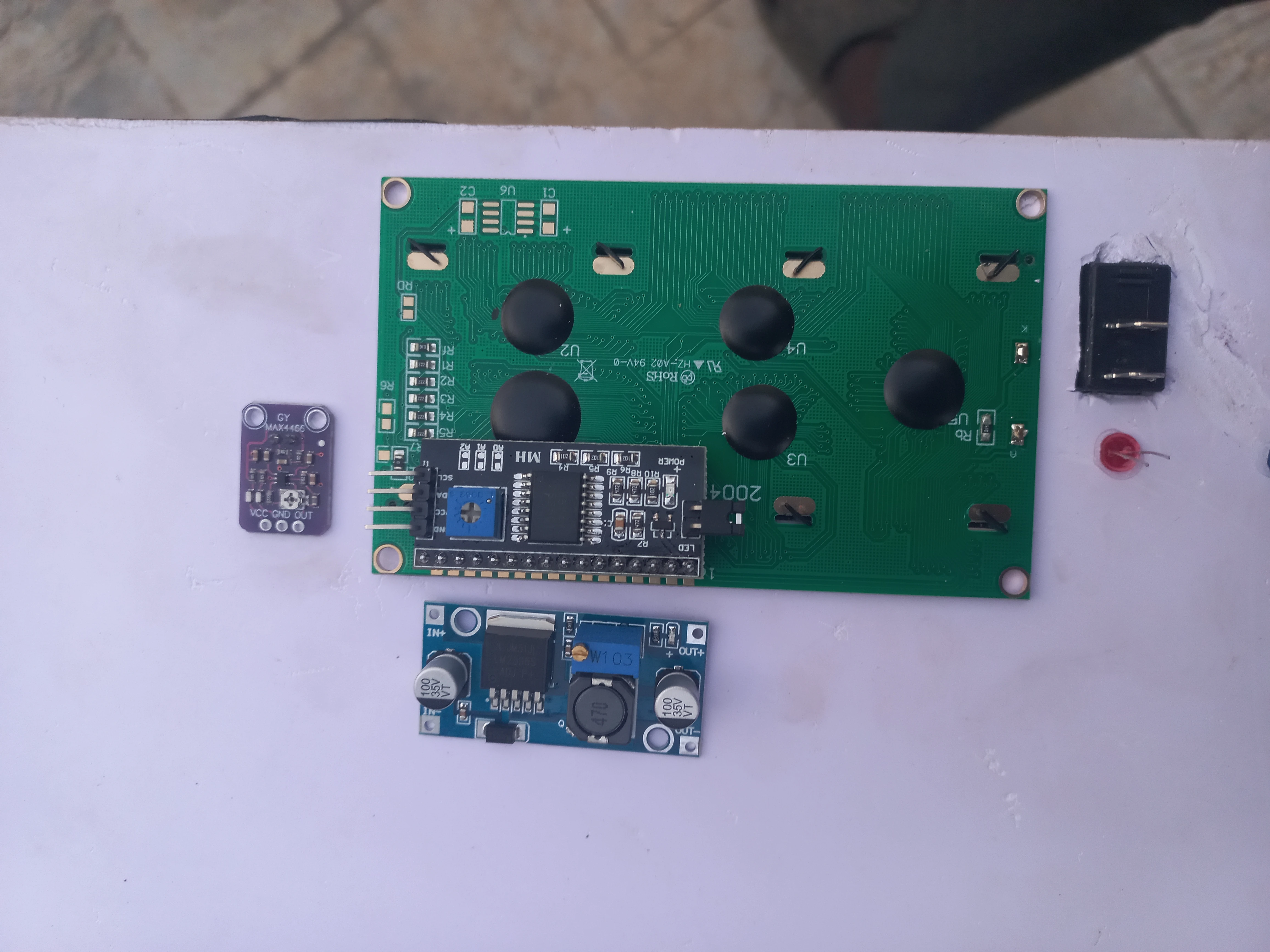Road unit components arranged before integration: ESP32, 20x4 LCD, MAX4466 microphone module, LM2596 buck converter, and wiring